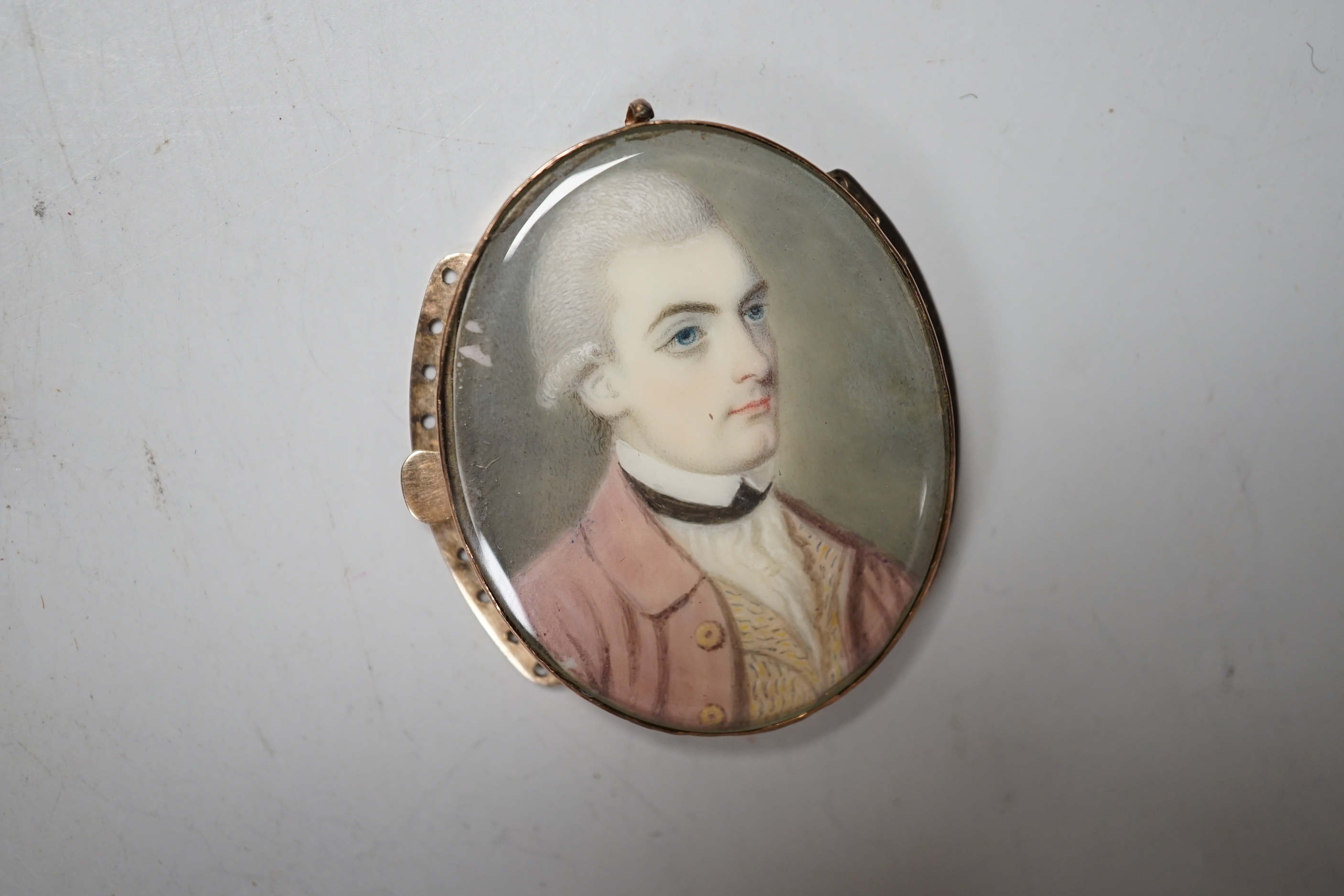 An 18th century oval portrait miniature on ivory of a gentleman wearing a frock coat, housed in a yellow metal mount, 4cm high CITIES submission reference 8D655XW4